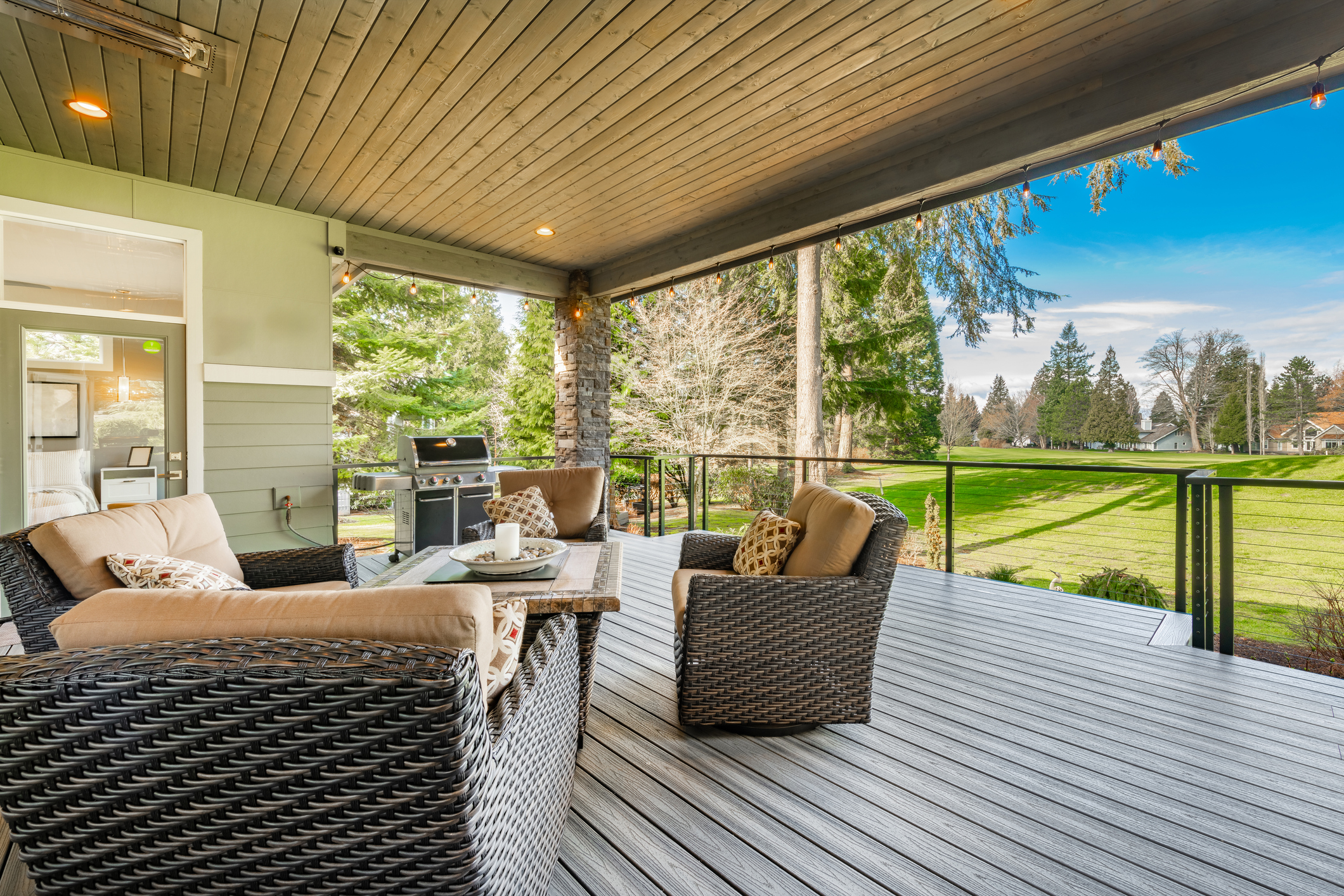 Covered composite deck with lounge furniture and yard view